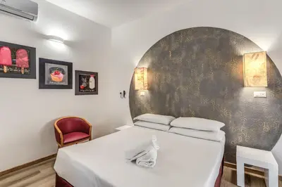 a bedroom with a bed and a red chair at Hotel Santa Prassede in Rome