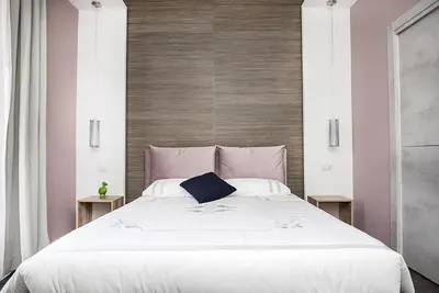 a large white bed with a blue pillow on it at My Love Suite in Rome
