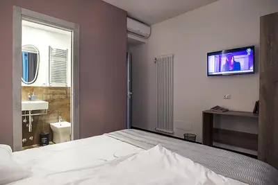 a bedroom with a bed and a tv on the wall at My Love Suite in Rome