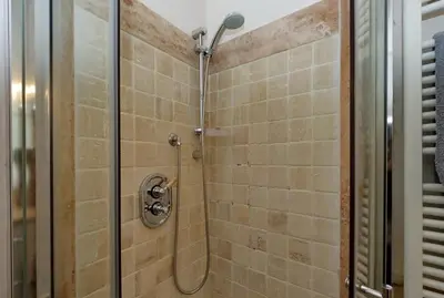 a bathroom with a shower with a glass door at Monti Charm by the Colosseum in Rome