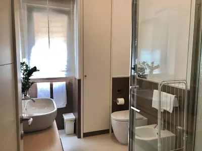 a bathroom with two sinks and a toilet and a shower at Visconti apartment. in Rome