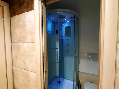 a glass shower in a bathroom with blue lighting at Gialli Vatican Guesthouse in Rome