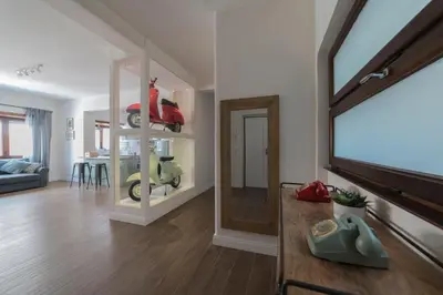 a living room with a mirror and a scooter on a shelf at Rhome Vintage Holidays San Pietro in Rome