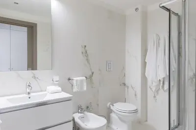 a white bathroom with a toilet and a sink at THE BREAK - Via Veneto Charming Suite in Rome