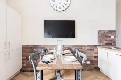 a dining room with a table with chairs and a tv at THE BREAK - Via Veneto Charming Suite in Rome
