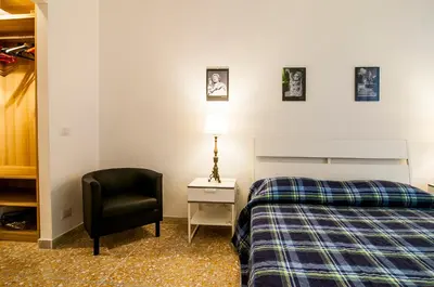 a bedroom with a bed and a chair and a lamp at GuestHost - Vatican Museums Cozy Flat x4 in Rome