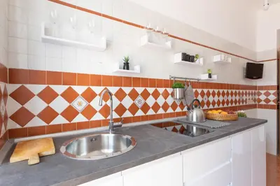 a kitchen with a stainless steel sink and tiles at Vatican Cozy Apartment with Terrace in Rome