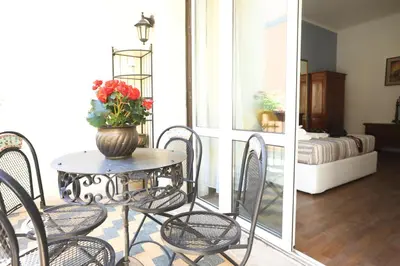a table and chairs with a vase of flowers on it at Unique luxury apartment and rooms in Rome