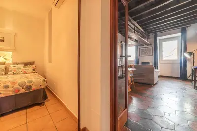 a bedroom with a bed and a living room at GuestHost - Colosseo & San Clemente Cozy Flat in Rome