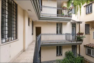 an alley in a building with balconies and plants at Roma Colosseum Apartment in Rome