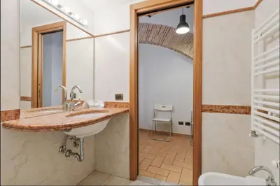 a bathroom with a sink and a toilet and a mirror at Roma Colosseum Apartment in Rome