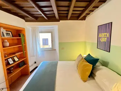 a bedroom with a bed with green and yellow walls at Charming Campo de' Fiori in Rome