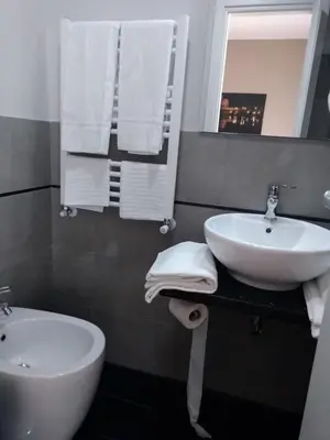 a bathroom with a sink and a toilet and a mirror at Roma suite Piramide in Rome