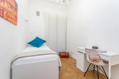 a white bedroom with a bed and a desk at Daplace - Matilde Apartment in Rome