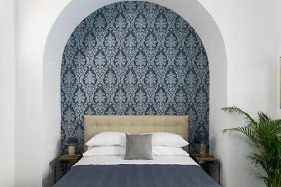 a bedroom with a bed with a blue and white wall at Horti Sallustiani Roma in Rome