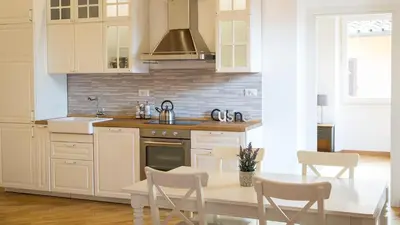 a kitchen with white cabinets and a table with chairs at Rental in Rome Trastevere Atmosphere in Rome