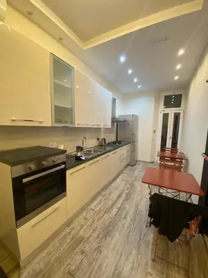 a kitchen with white cabinets and a sink and a table at Zeus Inn - Una finestra sul Vaticano in Rome