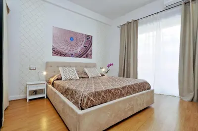 a bedroom with a bed and a large window at Merulana Suite S.Peter in Rome