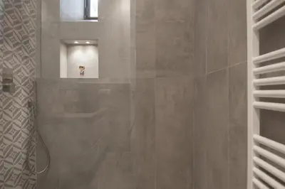 a bathroom with a shower with a dog in the mirror at 1 bdr apartments Ambio Suites Luxury Trastevere in Rome