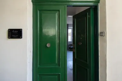 a green door leading into a room with a hallway at 1 bdr apartments Ambio Suites Luxury Trastevere in Rome