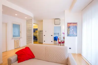 a living room with a couch with a red pillow at Dream House Vaticano in Rome