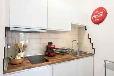 a kitchen with white cabinets and a sink at Flat Six in Rome