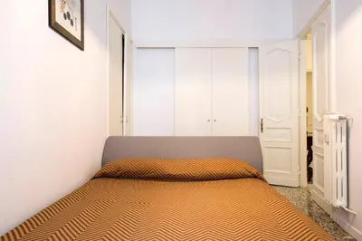 a bedroom with a bed in a white room at Flat Six in Rome