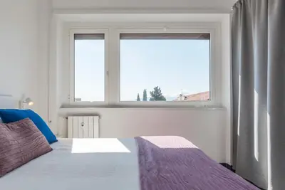 a bedroom with a bed and a large window at Nomentana White Apartments in Rome