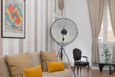 a living room with a couch and a fan at New! Spanish Step Design Apartment in Rome