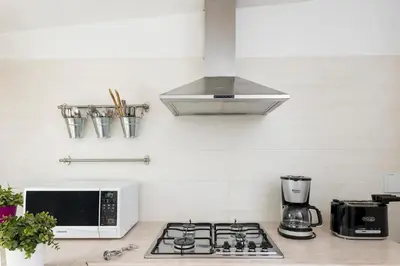 a kitchen with a stove top oven and a microwave at New! Spanish Step Design Apartment in Rome