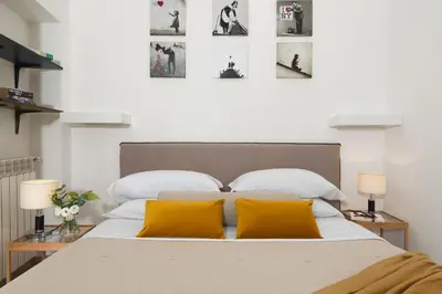 a bedroom with a large bed with two yellow pillows at Grotte Apartment near Campo dé Fiori in Rome