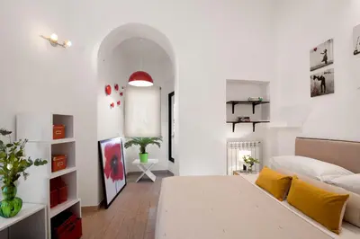 a bedroom with white walls and a bed with yellow pillows at Grotte Apartment near Campo dé Fiori in Rome