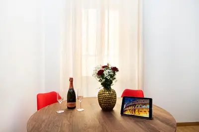 a table with a vase of flowers and a bottle of wine at Casa Bella Pantheon in Rome