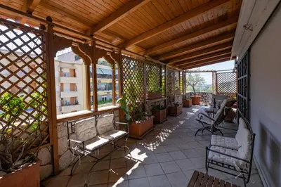 an outdoor balcony with chairs and potted plants at Amazing Penthouse with Terrace by Caracalla in Rome