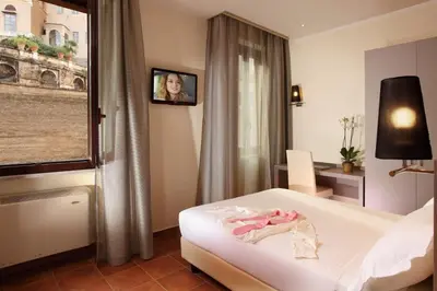 a hotel room with a bed and a tv on the wall at Hearth Hotel in Rome