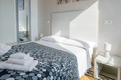 a white bedroom with a large bed and a mirror at St. Peter Central Rooms B&B in Rome