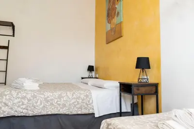 a room with two beds and a table with a lamp at St. Peter Central Rooms B&B in Rome