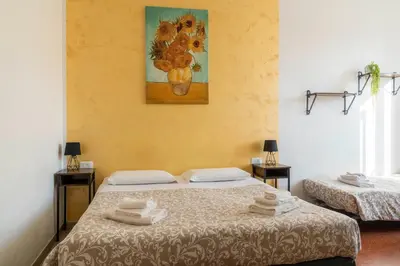 two beds in a room with a painting on the wall at St. Peter Central Rooms B&B in Rome