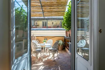 a door leading to a patio with a table and chairs at Frattina Apartments in Rome