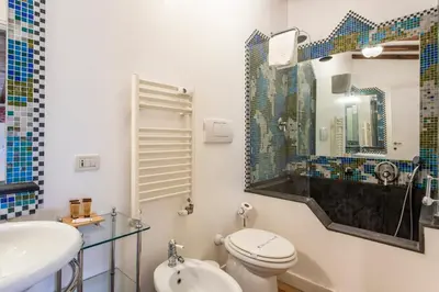a bathroom with a toilet and a sink and a mirror at Frattina Apartments in Rome