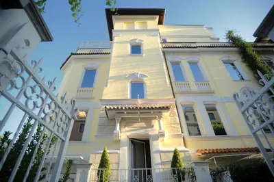 a white building with a gate in front of it at Hotel Villa Duse in Rome