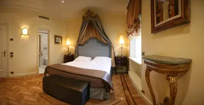 a bedroom with a bed and a table in it at Hotel Villa Duse in Rome