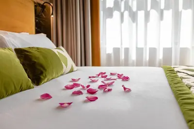 a pile of pink rose petals on a bed at NEMAN Maison Experience I Pantheon in Rome