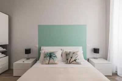 a white bedroom with a large bed with two night stands at La Dimora del Cardinale in Rome