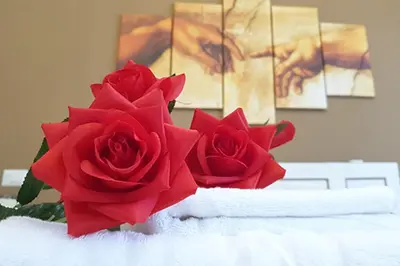 two red roses sitting on top of a table at Casa Ferrari Testaccio e Trastevere Wi-Fi free in Rome