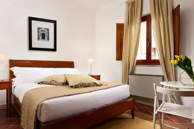 a bedroom with a bed and a table and a window at Roma Resort Termini in Rome