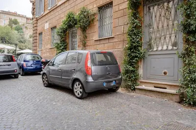 a small silver car parked next to a building at Roman Forum Apartment - The Heart of Rome in Rome