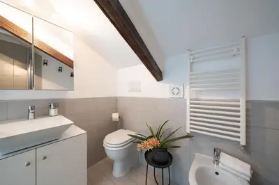 a white bathroom with a toilet and a sink at Vic Pigneto, Luxury House Terrace Roma in Rome