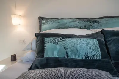 a bed with black and white pillows on it at Vic Pigneto, Luxury House Terrace Roma in Rome