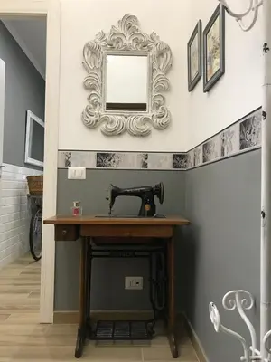 a mirror on a wall above a table with a sewing machine at Da Nonna Maria in Rome